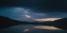 a lake under dark clouds on a cloudy night