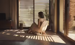 a woman sitting in a chair looking out the window