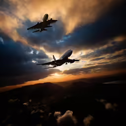 two planes flying against a cloudy sky with the sun rising behind them