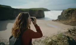 a person is taking pictures while standing on a hill