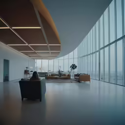 a long, empty room with big windows and lots of seating