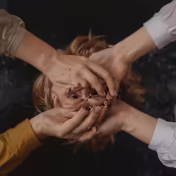 a close - up photo shows hands reaching together to each other