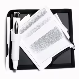 black tray with silver glittery papers and a pens