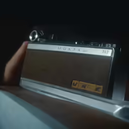 a person is holding a radio with a sign on it