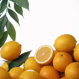 a pile of citrus fruit with leaves on the side
