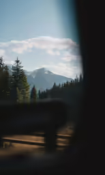 the mountains and trees are shown in the reflection of the car windshield