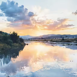 the sun setting over the water near a river