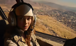 the female pilot of the airplane is looking over the city