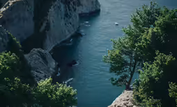 an image of a rocky shore with boats on the water