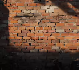 a shadow cast on a brick wall as if someone fell a piece of luggage