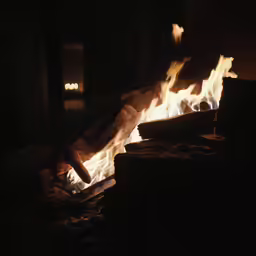a person reaching for some flame in the dark
