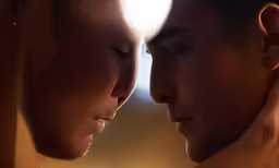 two men that are standing close together, one staring at the other