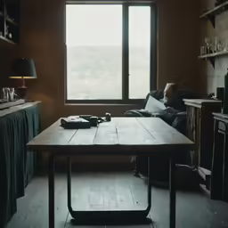 a person sitting in a chair reading at a table