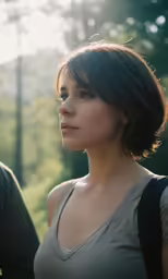 a woman with a camera bag looking down into the distance