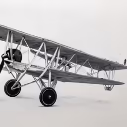 an old biplane sits in a snow covered area
