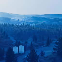 the view of a mountain area with two towers and trees in the foreground