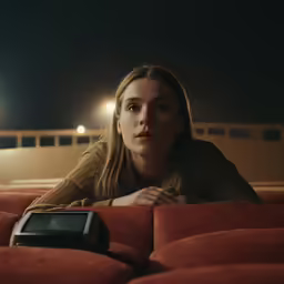 a person sitting in a chair next to a remote control