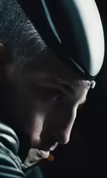 a man with a motorcycle helmet in a dark room