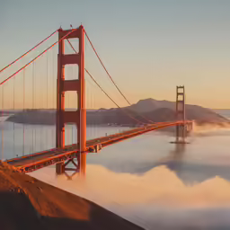 an image of a bridge and mountains that appear to be fog