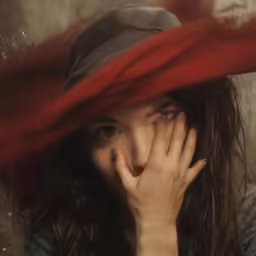 the woman is covering her face with a red blanket
