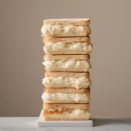 a stack of three stacks of white toast with cheese