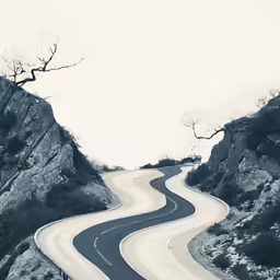 a curvey road winding around two large rocks