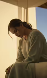 woman sitting down with her hands clasped in prayer