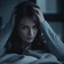 a beautiful woman sitting in bed with her hands on the head