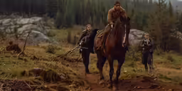 two people are riding horses near trees