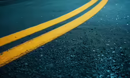 the road is wet and yellow with no cars on it