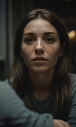 a woman with long hair is looking at the camera