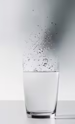 a glass with water in it floating in the air