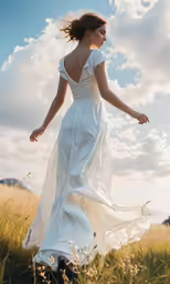 woman in flowing white dress walking through a field