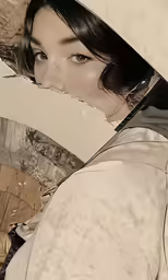an asian woman with short dark hair wearing an umbrella hat