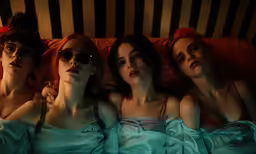 three people that are laying in a bed