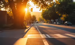 an empty road with traffic at sunset in the background