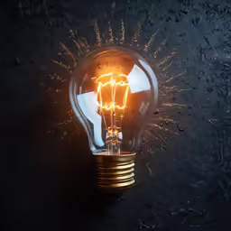 a bright light bulb on top of some dark rocks