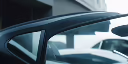 the side mirror of a vehicle with a parked car behind it