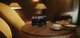 an old camera and some small cups on a table