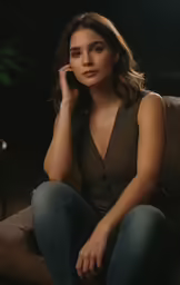a women who is sitting on a couch talking on the phone