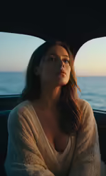 a beautiful woman sitting in the back of a car