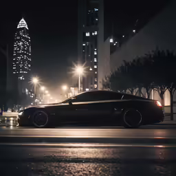a black car driving down a street at night