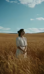 a woman standing in the middle of a field of tall grass