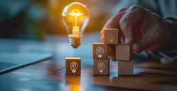 two wooden cubes with the symbol of a light bulb,a person