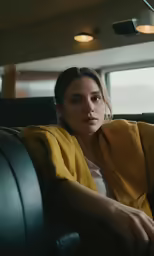 a woman sitting in a chair, looking off to the side