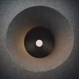 looking down into a dark space, with a round light fixture on the left and right side of the wall