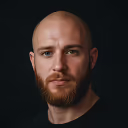a close - up of a man with a bald head, posing for a portrait