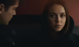a woman standing next to a man in black