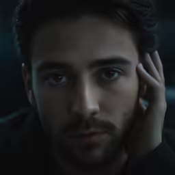 a close up of a person holding his head in their hand