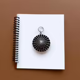 a spiral design keychain and notepad on top of a paper